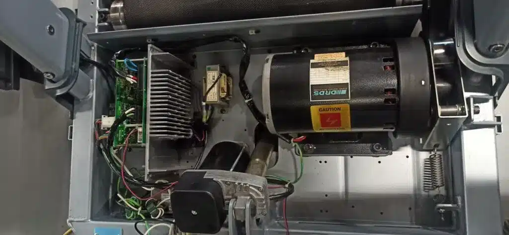 Open treadmill showing motor, heat sink, and wiring