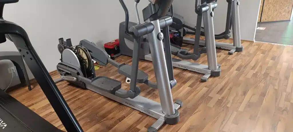 Service technician performing diagnostic check on elliptical trainer