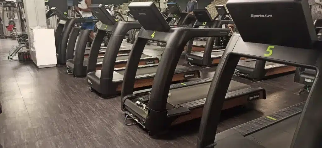 Technician replacing the motor on a professional treadmill