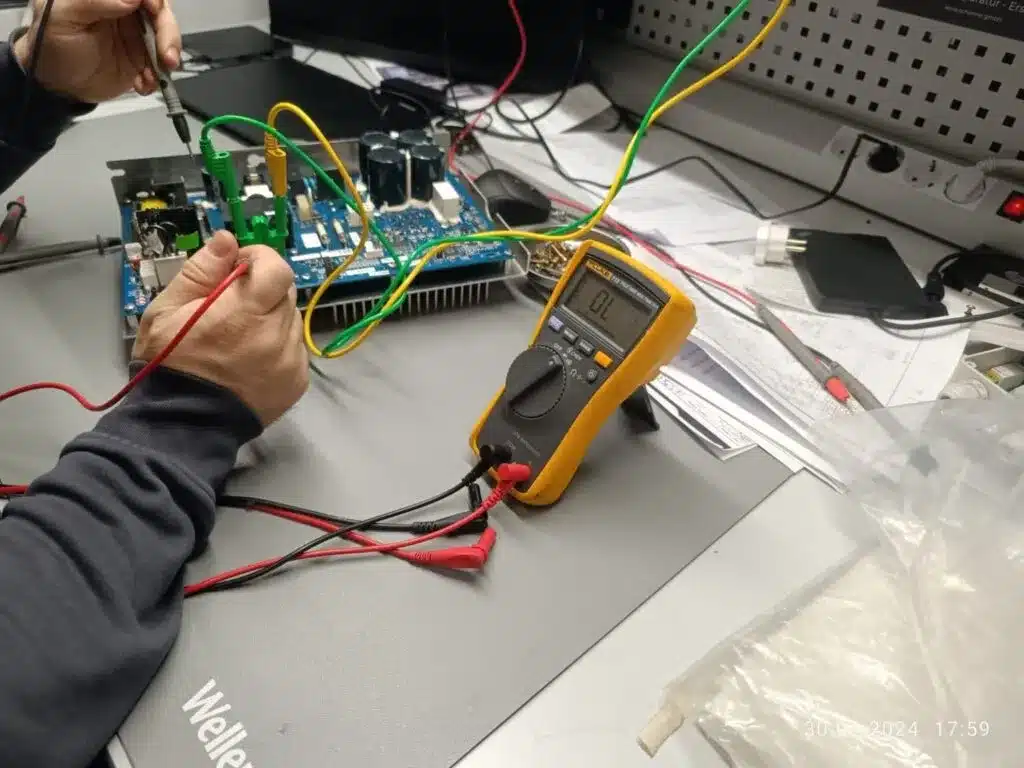 Technician measuring voltage on a circuit board from a treadmill