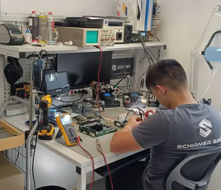 Service technician working on treadmill electronics at a workstation